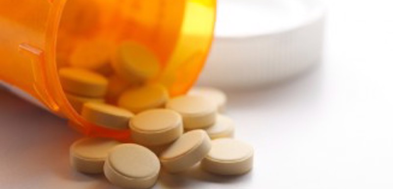 En medicinburk med uthällda tabletter