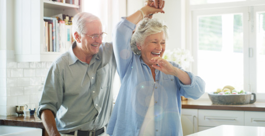 Ett äldre par dansar i sitt kök