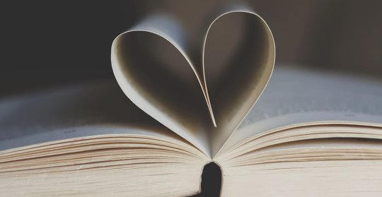 Uppslagen bok, där två blad bildar ett hjärta