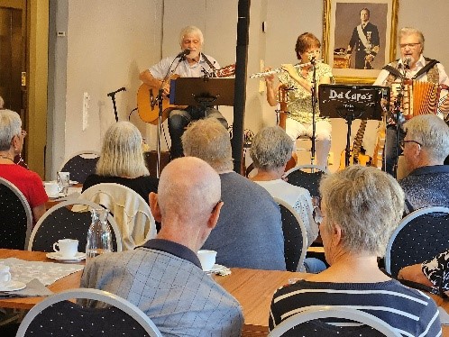 Medlemmar som lyssnar på en grupp musiker
