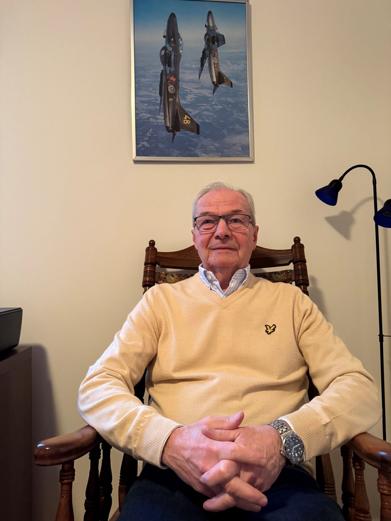 Leif Hellgren med tavla på stridsflygplan bakom sig