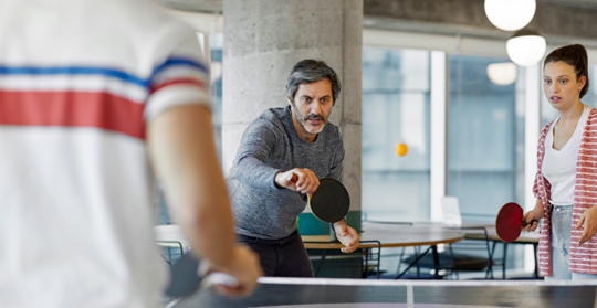 Tre personer spelar bordtennis