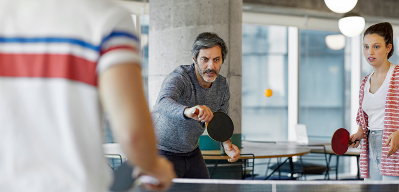 Tre personer spelar bordtennis