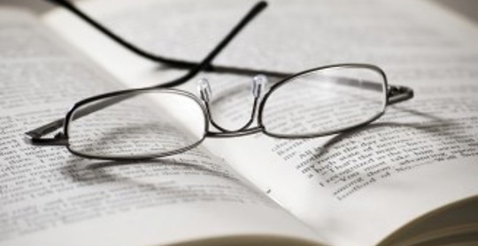 Ett par glasögon i en uppslagen bok